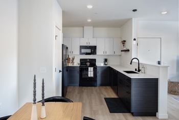 a kitchen with white cabinets and black appliances